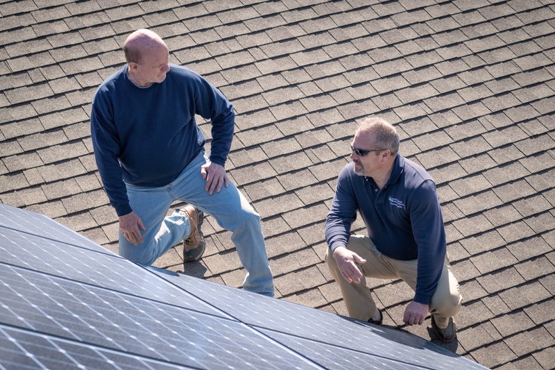 South River EMC Energy Services Adviser Robbie Talton (right) checks out David Page’s solar installation