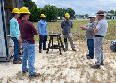 Farris Leonard (second from right) speaks with an electrical lineworker class at James Sprunt Community College.
