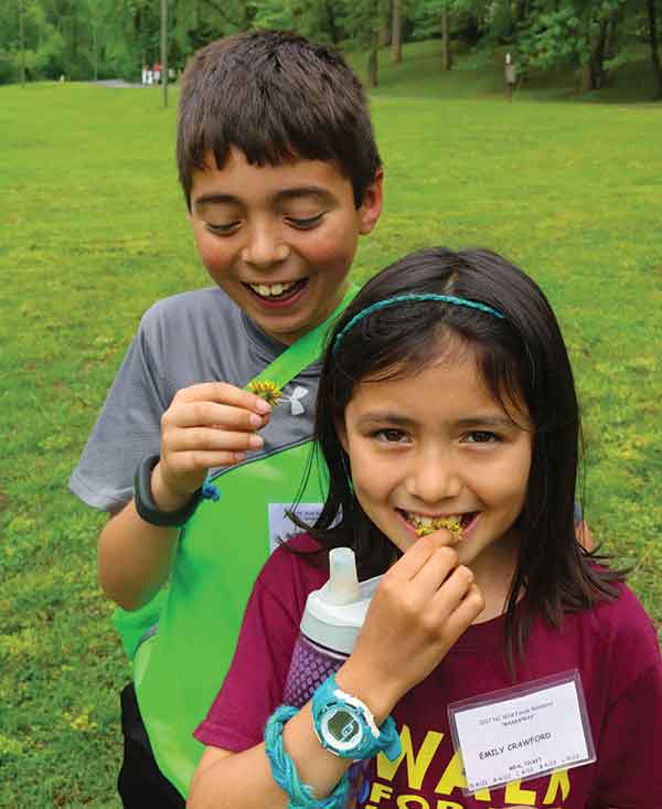 Emily Crawford and her brother Gio try dandelion flowers.