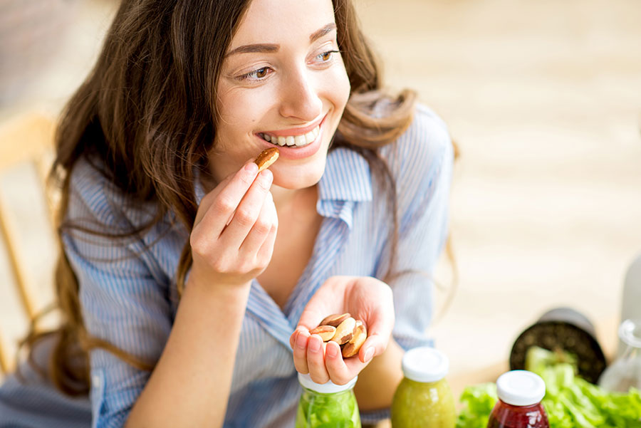 woman eating brasil nuts